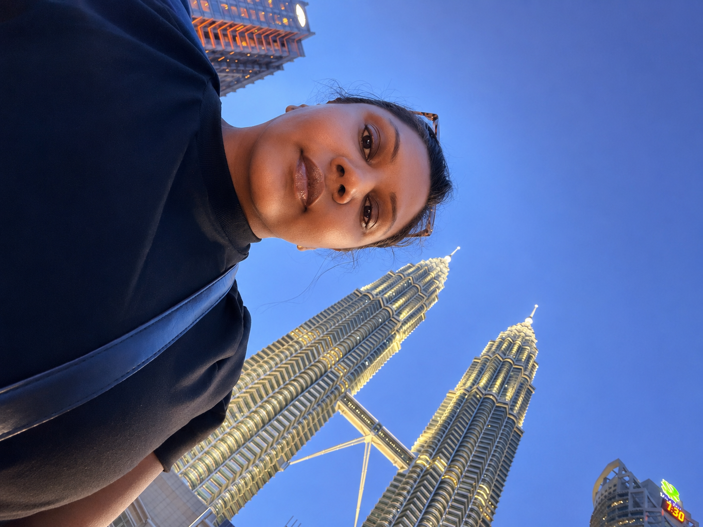 Solo female traveller at the Petronas Twin Towers during a public-transport journey through Malaysia.