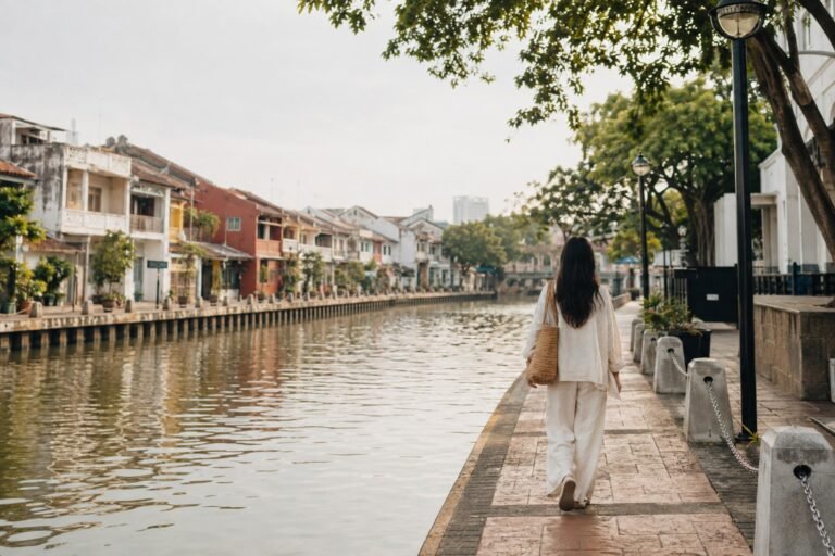 Solo female traveller beside the Melaka River and historic shophouses